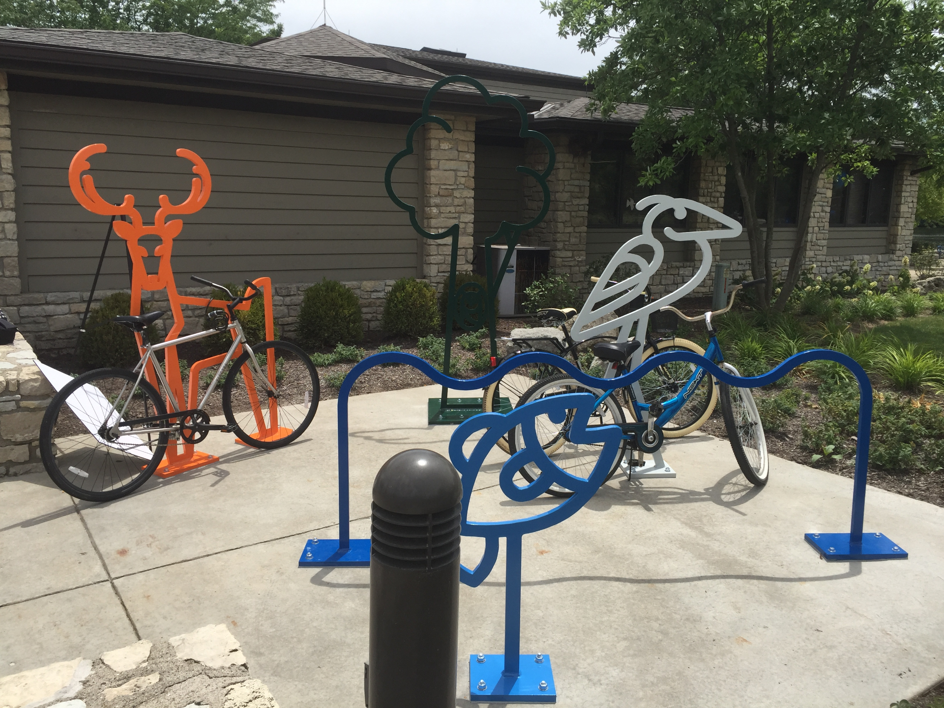 Custom animal-shaped bike racks with deer, tree, bird, and wave designs