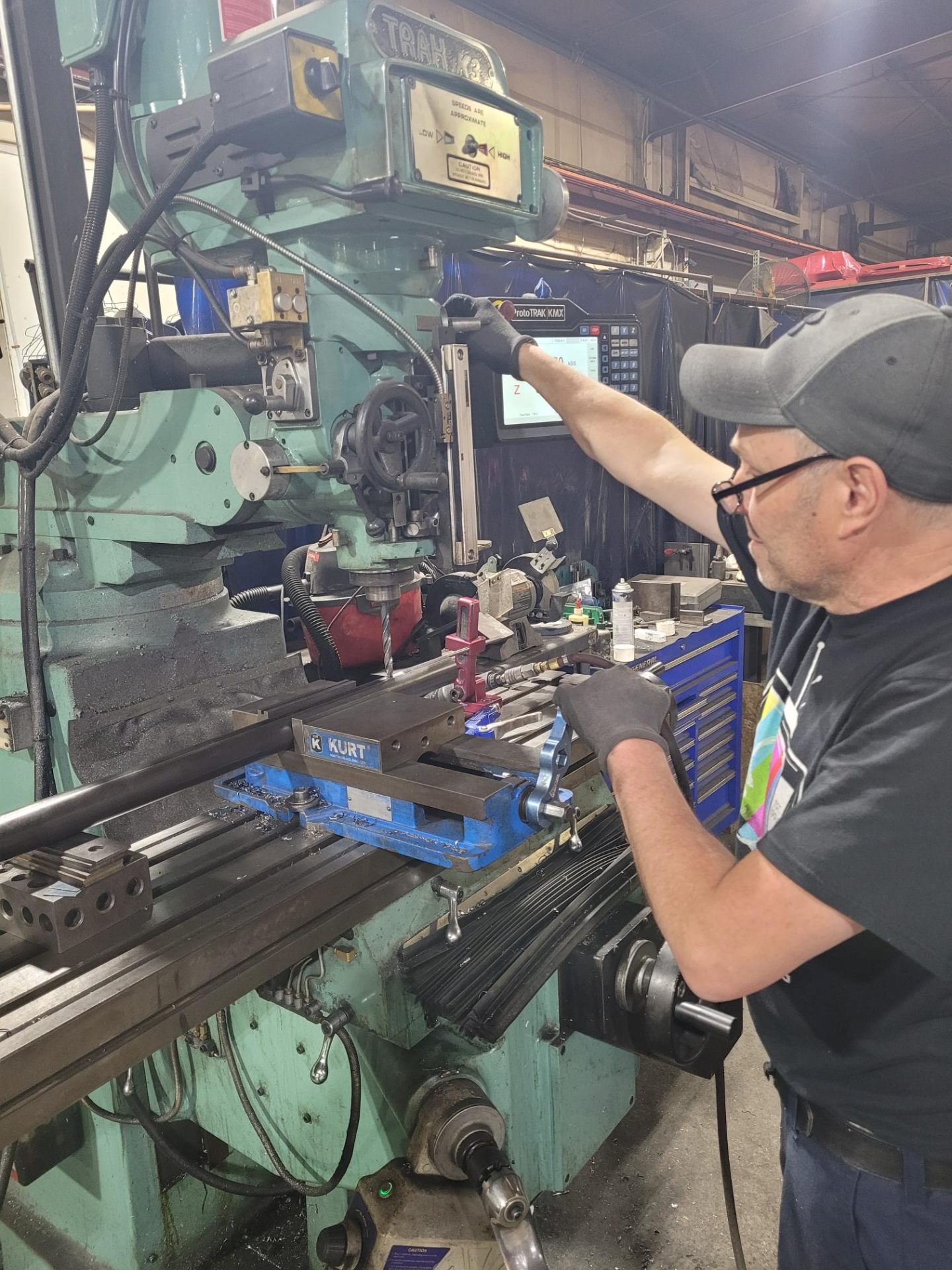 Machinist operating a ProtoTRAK KMX milling machine