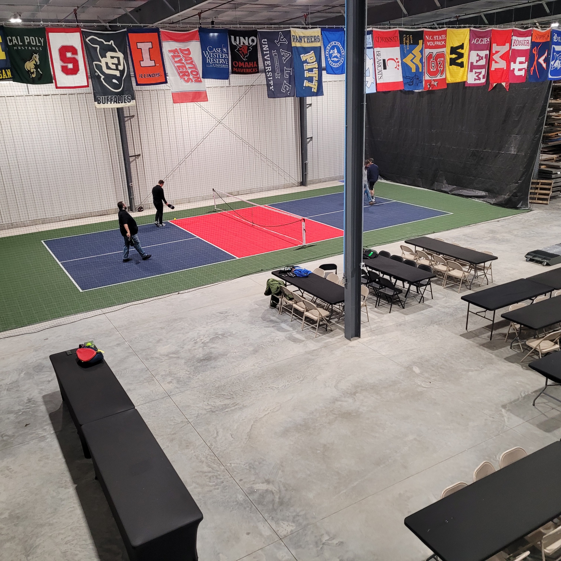 CMF pickleball court with college banners and seating area