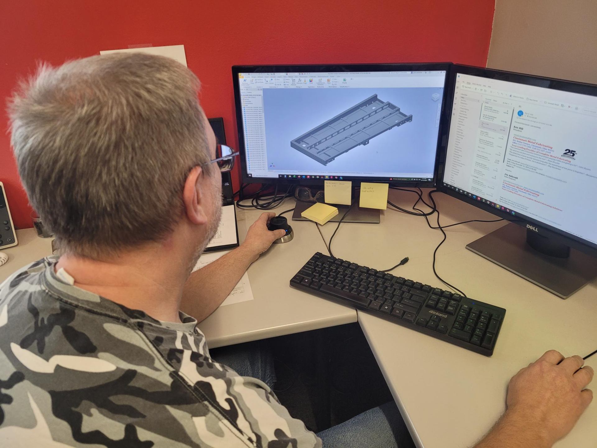 CAD designer reviewing 3D model on screen