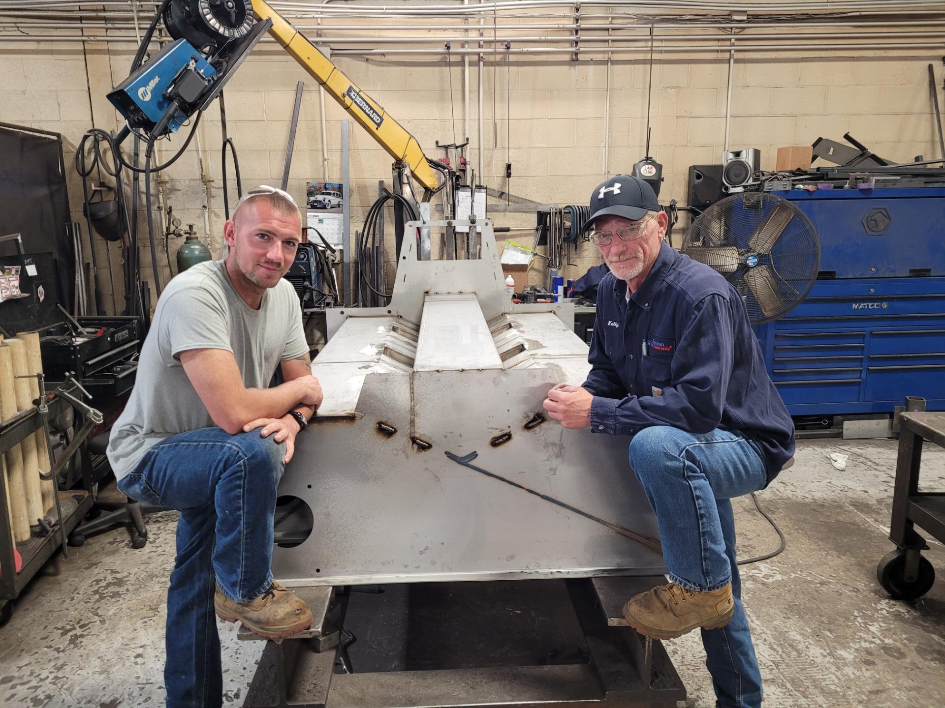 Two expert fabricators posing with precision stainless steel weldment