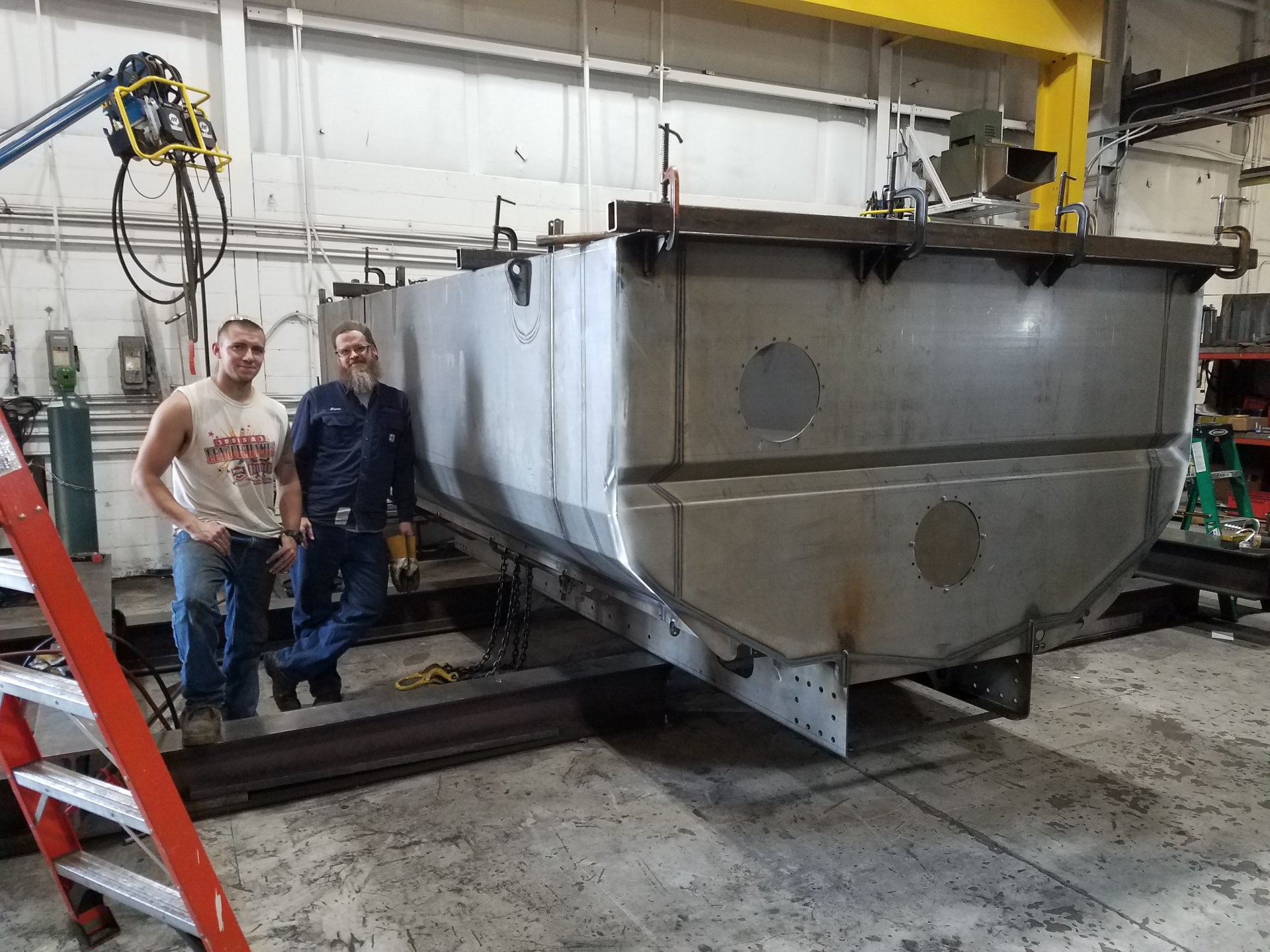 Welders standing with large tank they fabricated