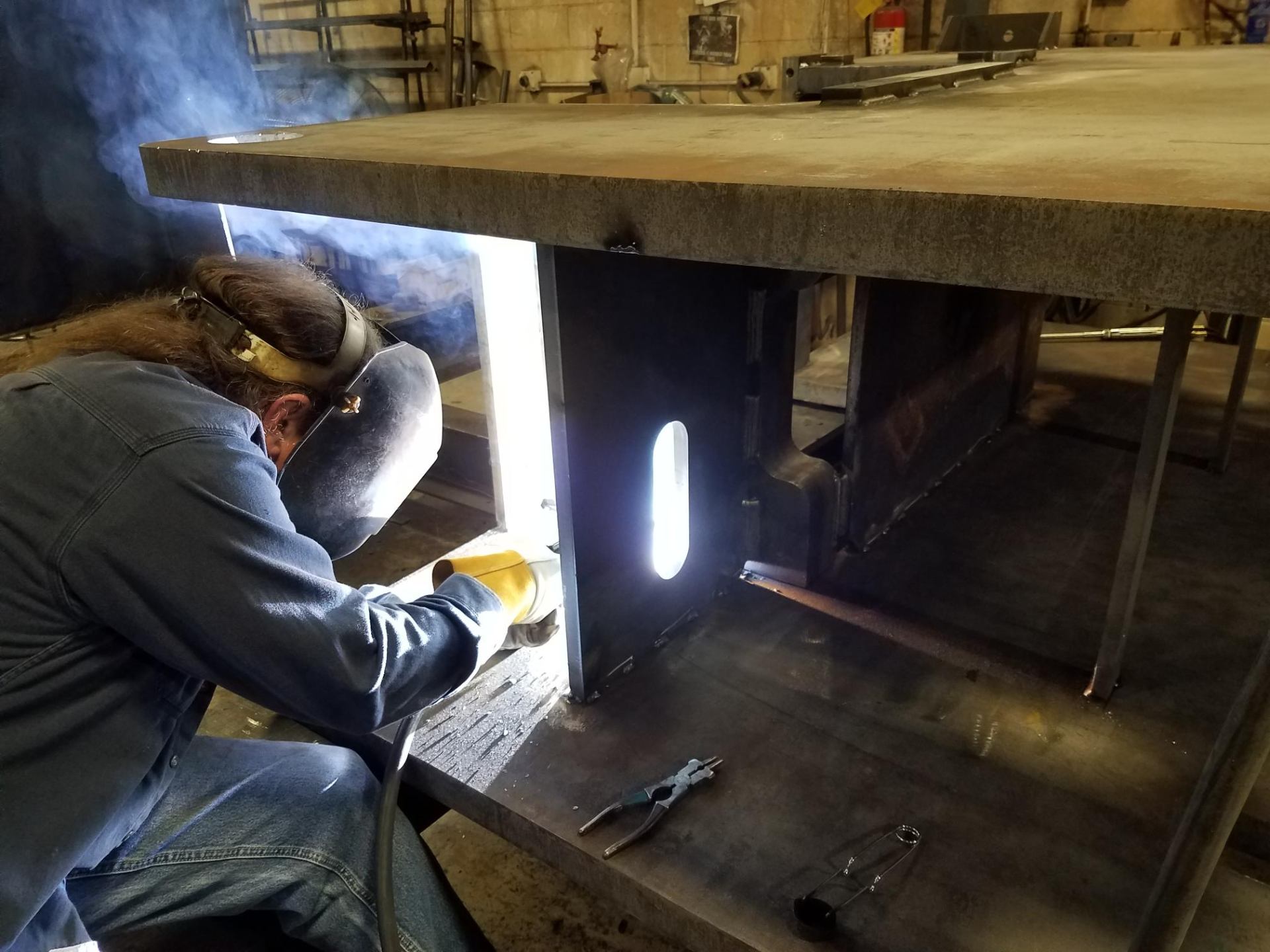 Welder with torch on heavy steel assembly