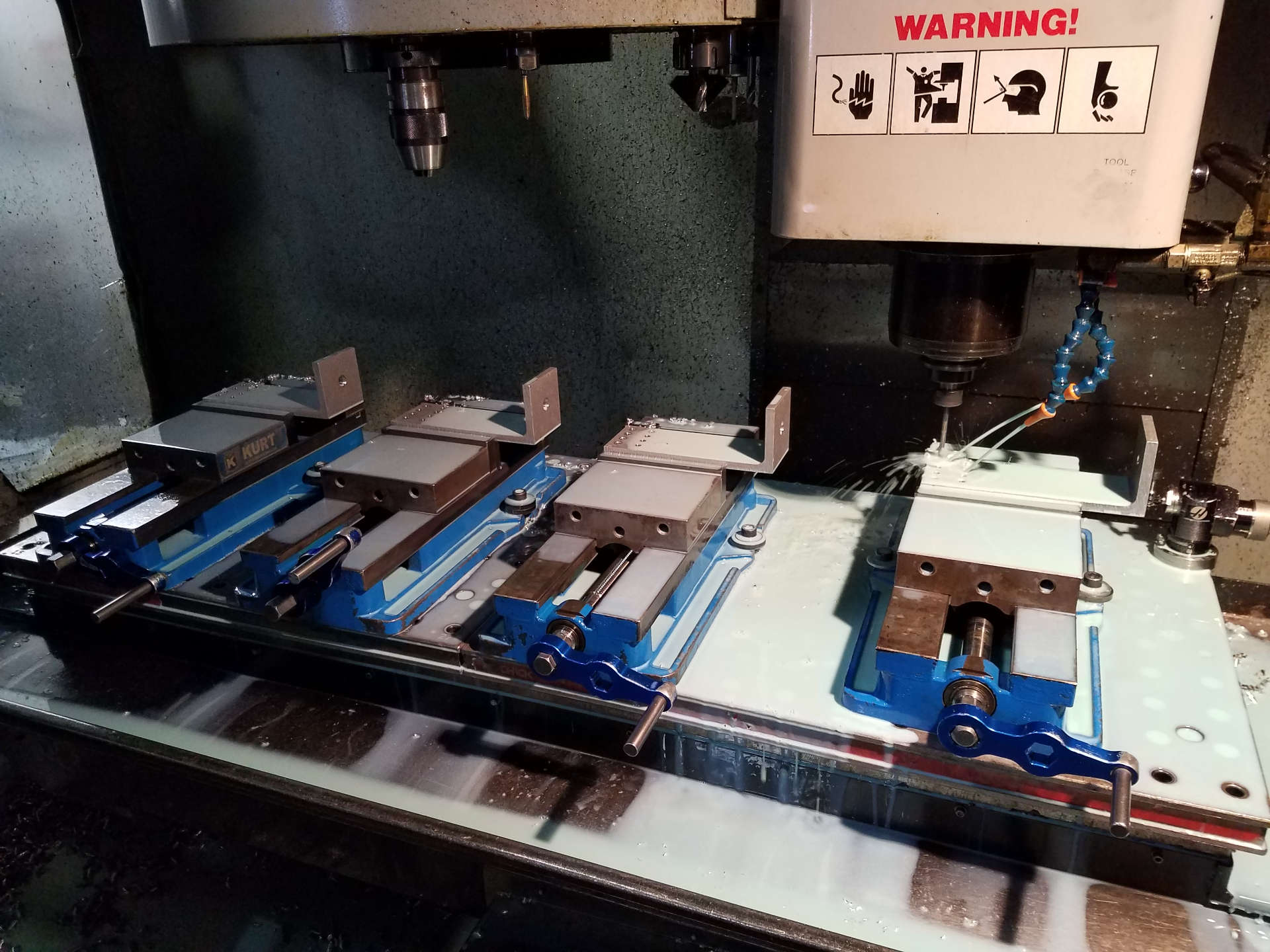 CNC machining center with multiple vises producing aluminum parts
