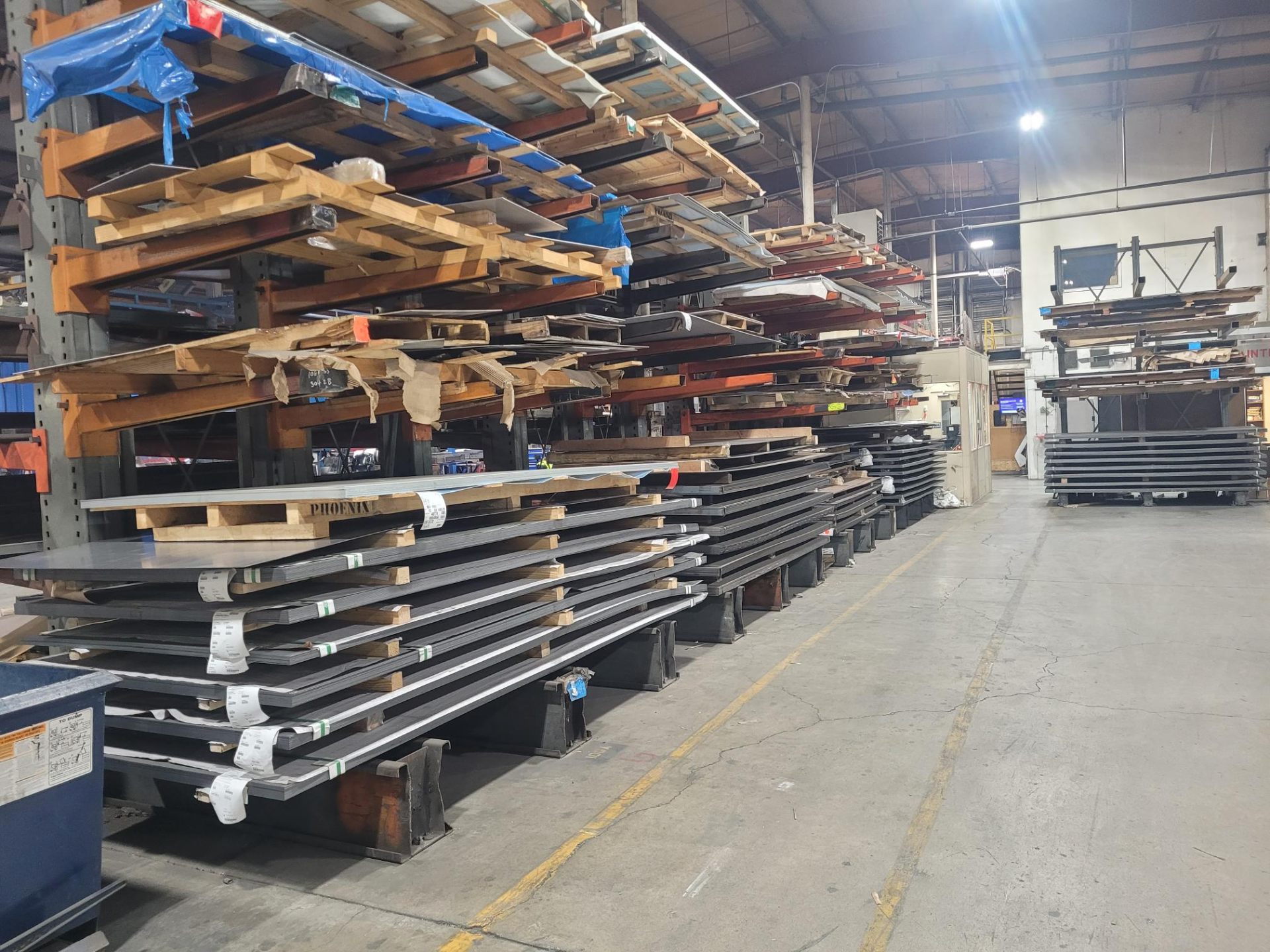 Rows of labeled steel and aluminum sheets in warehouse